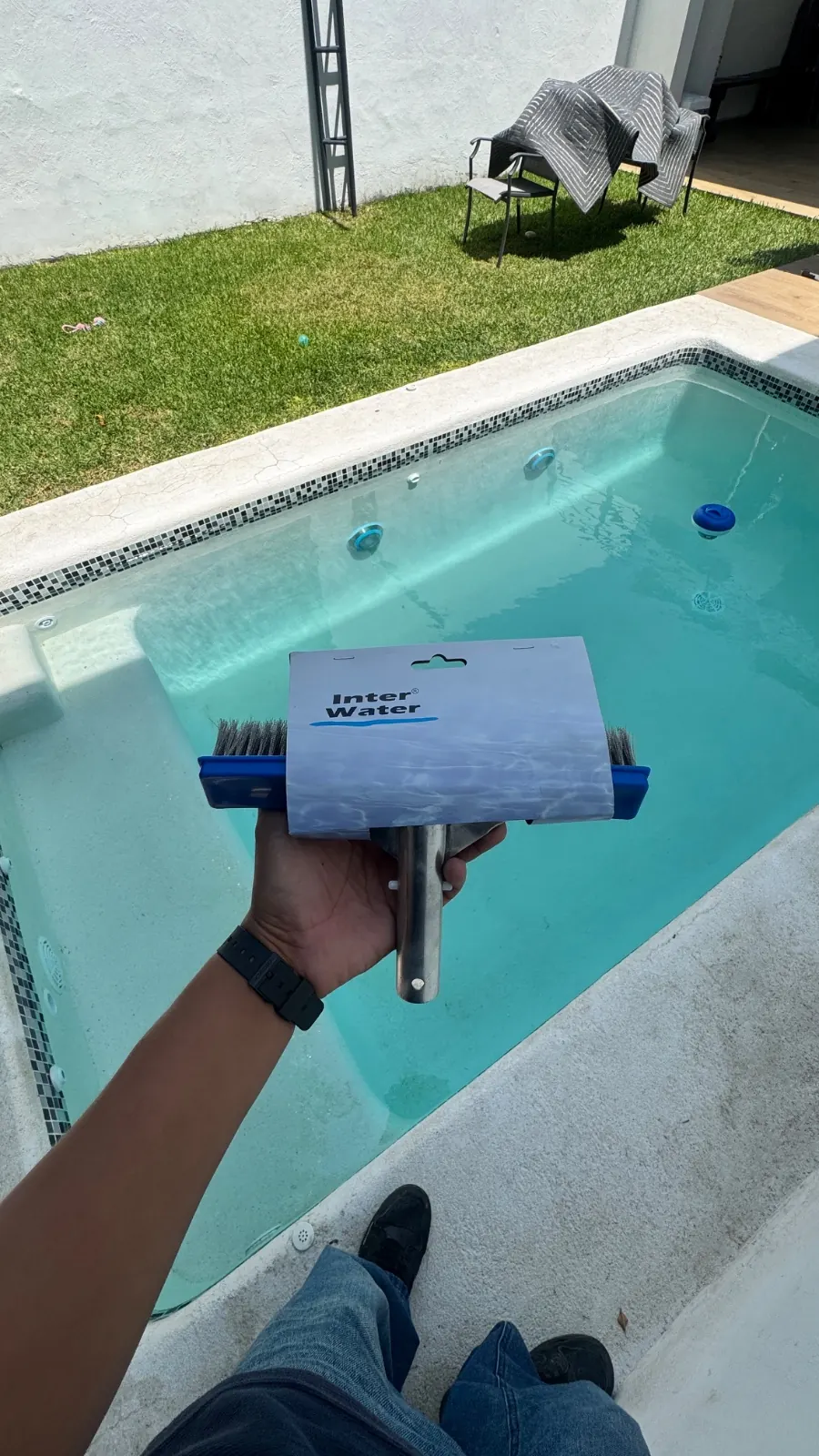 Cepillado de los muros de una alberca con agua clara