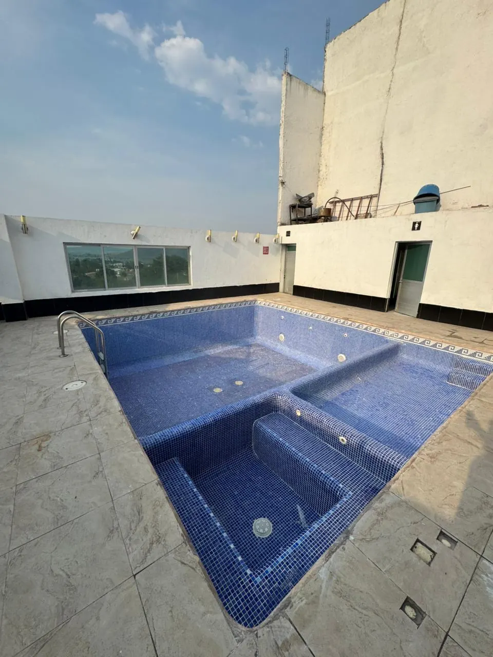 Alberca vacía con escalón y mosaico azul antes de reponer piezas